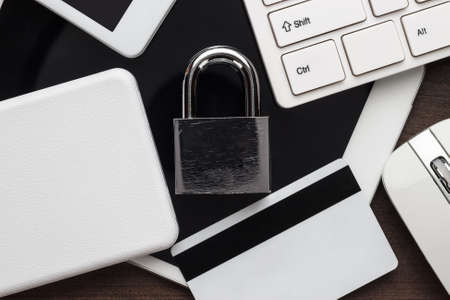 padlock and different gadgets on the wooden office table. privacy protection, encrypted connection...