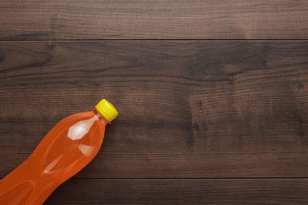 plastic bottle of orange soda on wooden tableの写真素材