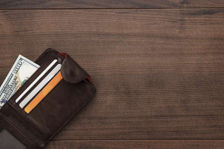 men's purse with money, credit and debit cards on the wooden tableの写真素材