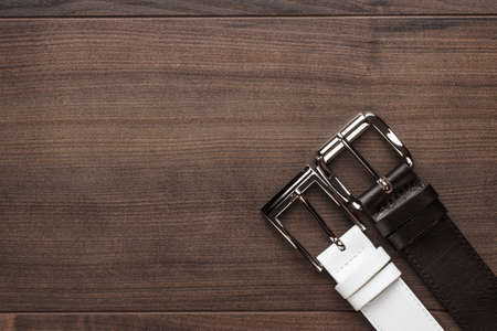 brown and white men's leather belts on wooden tableの写真素材
