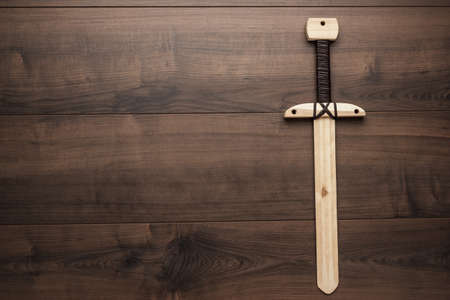 handmade wooden training toy sword on the tableの写真素材