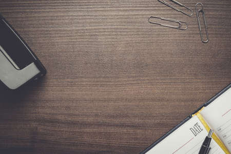 office brown wooden table with pen and notebook background