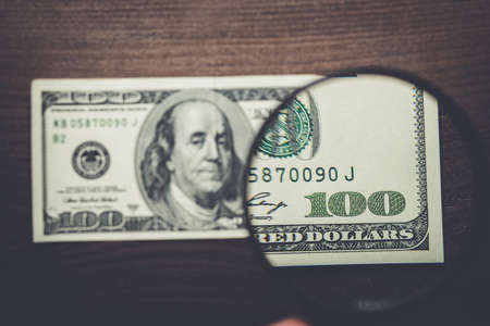 one hundred dollars banknote authentication on wooden backgroundの写真素材