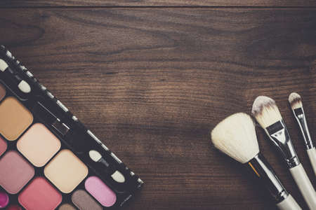 white make-up brushes on brown wooden backgroundの写真素材