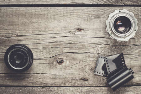 retro camera lenses and negative film on wooden table