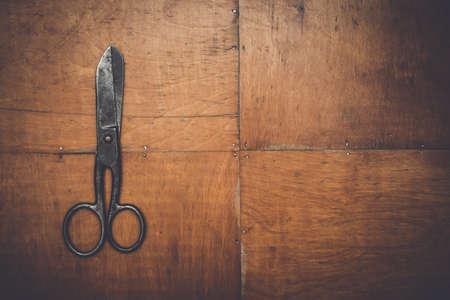 old black scissors on the wooden backgroundの写真素材