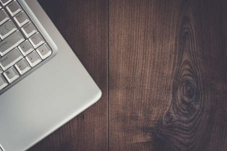 laptop on the brown wooden table backgroundの写真素材