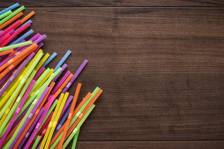 colorful striped bendy cocktail straws on wooden tableの写真素材