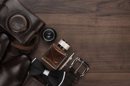 men's accessories in order on the brown wooden table overhead view with copy spaceの写真素材