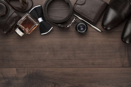 men's accessories in order on the brown wooden table overhead view with copy spaceの写真素材