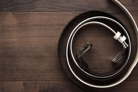 brown and white men's leather belts on wooden tableの写真素材
