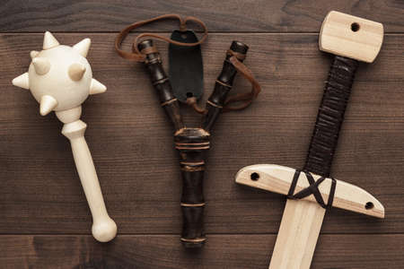 handmade wooden training toy sword and slingshot on the tableの写真素材
