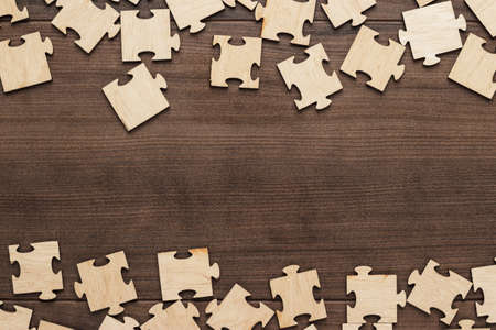 incomplete puzzle pieces on brown wooden tableの写真素材