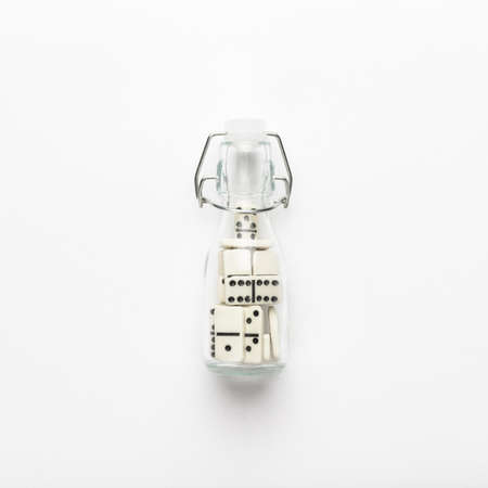 dominos in the bottle on the white background. conceptual image. not isolatedの写真素材