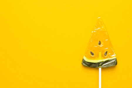 sugar watermelon lollipop on bright yellow background with some copy spaceの写真素材