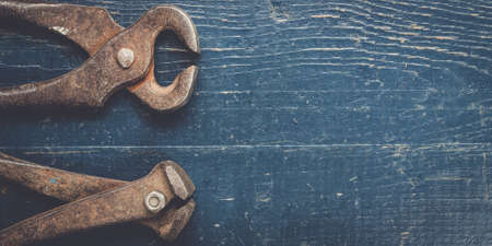 old rusty tongs on blue wooden backgroundの写真素材