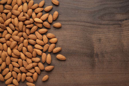 many almond seeds on the wooden table backgroundの写真素材