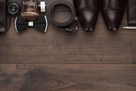 men's accessories in order on the brown wooden table overhead view with copy spaceの写真素材
