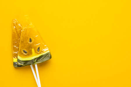 sugar watermelon lollipops on bright yellow background with some copy spaceの写真素材