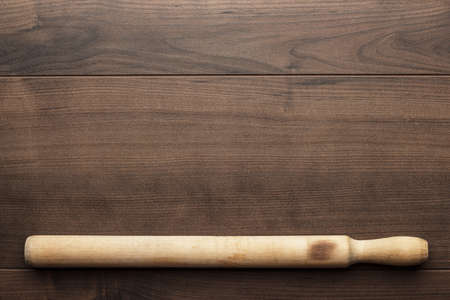 old wooden rolling pin on brown tableの写真素材