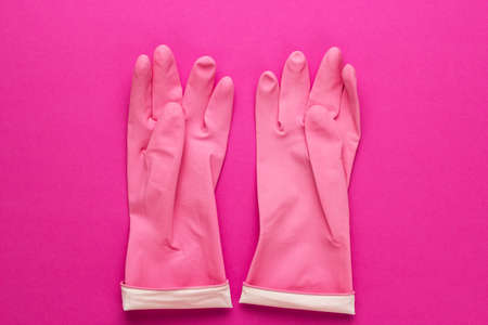 pink rubber cleaning gloves on bright purple background