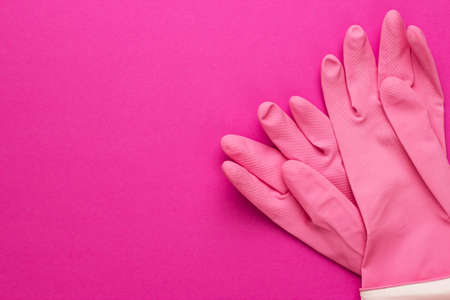 pink rubber cleaning gloves on bright purple backgroundの写真素材