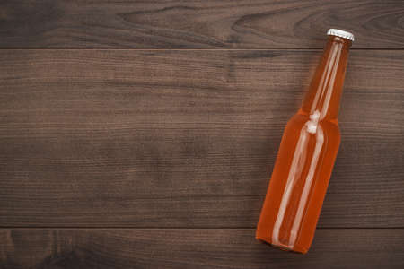 glass bottle of orange soda drink on wooden backgroundの写真素材