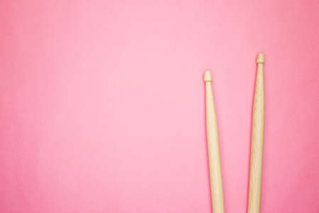 pair of wooden drumsticks on pink backgroundの写真素材