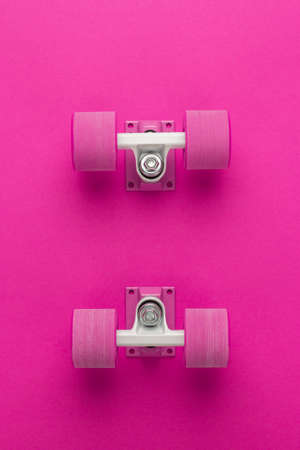 cruiser skateboard trucks and wheels on deep pink with background copy spaceの写真素材