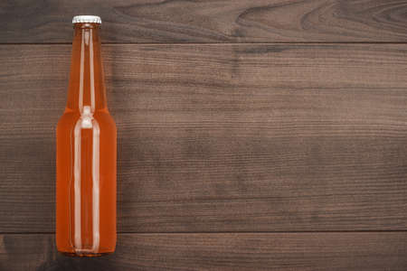 glass bottle of orange soda drink on wooden tableの写真素材