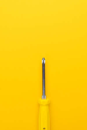 close-up of manual screwdriver with plastic handle on the yellow backgroundの写真素材