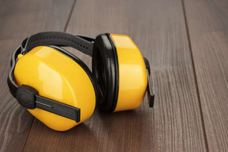 hearing protection yellow ear muffs on wooden tableの写真素材