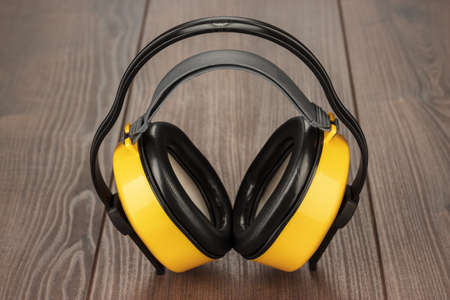 hearing protection yellow ear muffs on wooden tableの写真素材