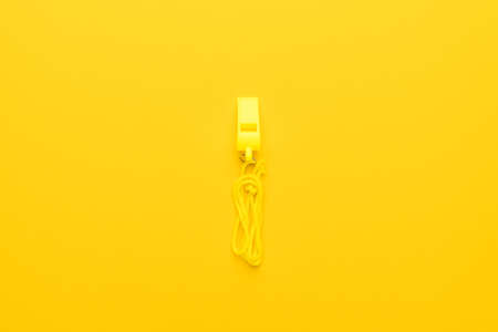 plastic referee whistle on the yellow backgroundの写真素材
