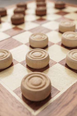 wooden draughts board game on brown table