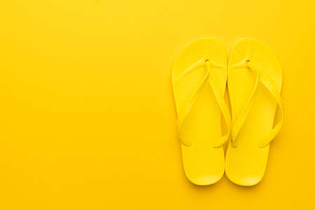 beach flip-flops on the yellow background with copy space. summer is conceptの写真素材