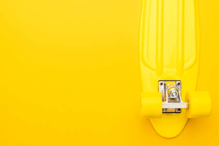plastic mini cruiser board on yellow background. bright yellow cruiser skateboard with copy spaceの写真素材