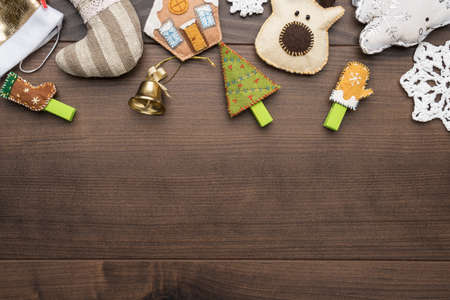 Christmas decorations on brown table. different christmas toys over wooden background. preparation for christmas celebration with copy space. handmade toys for decorating traditional christmas treeの写真素材
