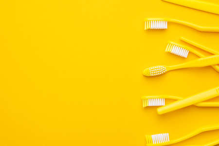 Many new plastic toothbrushes on the yellowの写真素材