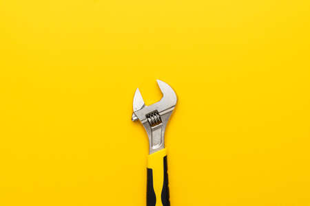 Adjustable wrench with yellow handle on the yellow