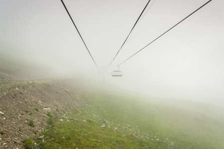 Cable way in the mountains on foggy day. alpine landscapeの写真素材