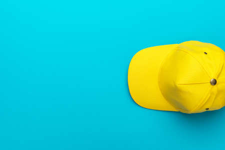 Top view of the yellow baseball cap over the blue turquoiseの写真素材