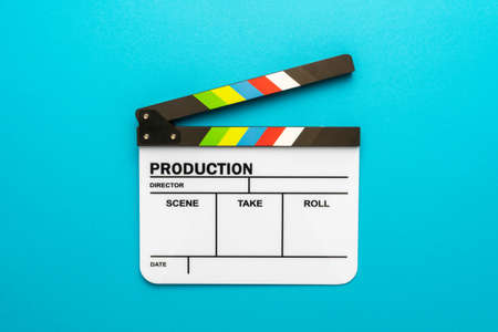 Top view  of open white clapperboard over turquoise blueの写真素材