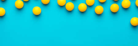 many balls for table tennis on turquoise blue background. flat lay image of many yellow table tennis balls with copy space. minimalist photo of yellow equipmentの写真素材