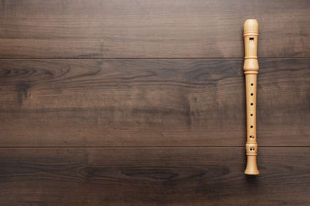 Wooden recorder on the wooden background. Overhead photo of block flute with copy space.の写真素材