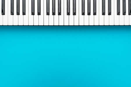 Top view of piano keys with copy space. Minimalist photo of midi keyboard over turquoise blue background.の写真素材