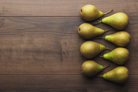 Fresh pears on the brown table. Flat lay photo of pears on wooden background with copy space.の写真素材