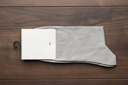 New pair of gray socks with blank packing with copy space. Flat lay photo of new socks on wooden background.の写真素材