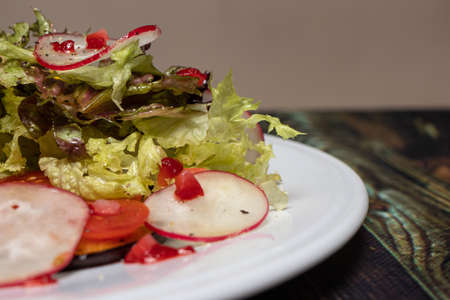 Vegetable salad with radish and lettuce lattuke on a white plate. Weight loss, proper nutrition, healthy food to maintain health. Keto Dietの写真素材