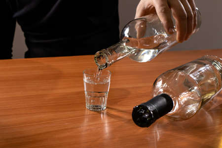 A man and a glass of vodka. Alcoholism, alcohol addiction, delirium tremens.の写真素材